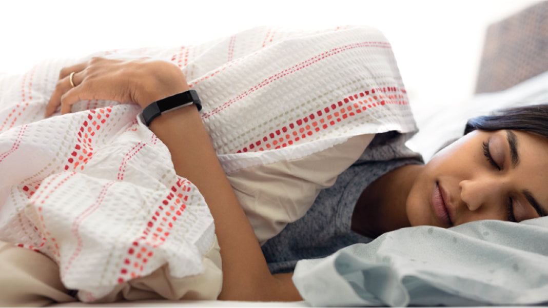 woman sleeping while wearing a monitor on her wrist