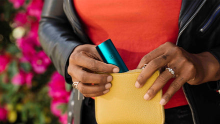 Person removing a PAX vaporizer from a small coinpurse