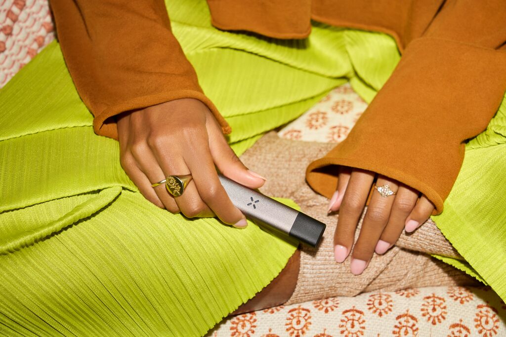 Someone holding a PAX ERA vape pen with a pod inserted