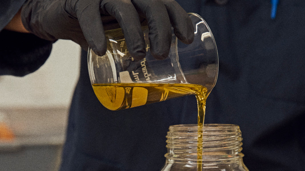 Cannabis oil extract being poured from a beaker