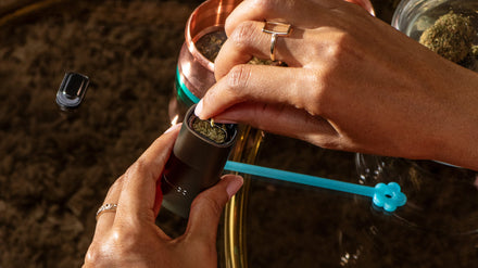 A PAX dry herb vaporizer being packed with cannabis