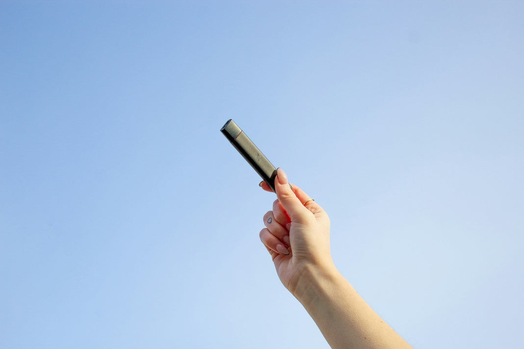 Holding up a PAX ERA vape pen against the sky