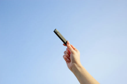 Holding up a PAX ERA vape pen against the sky