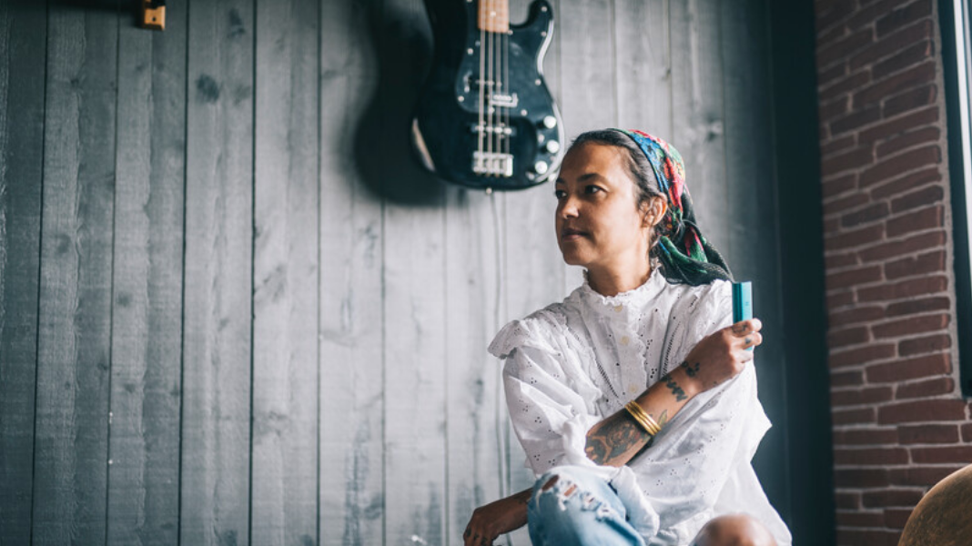 Woman sitting and holding a PAX vape