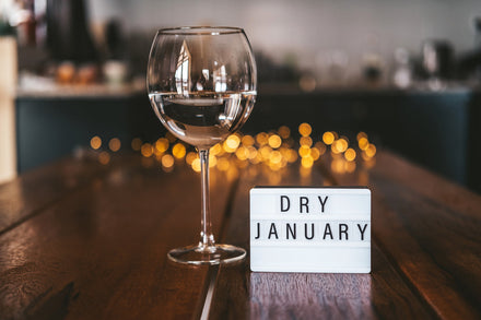 Image of an empty wine glass next to a Dry January sign