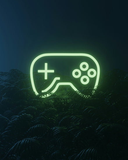 neon video game controller sign in a field of plants
