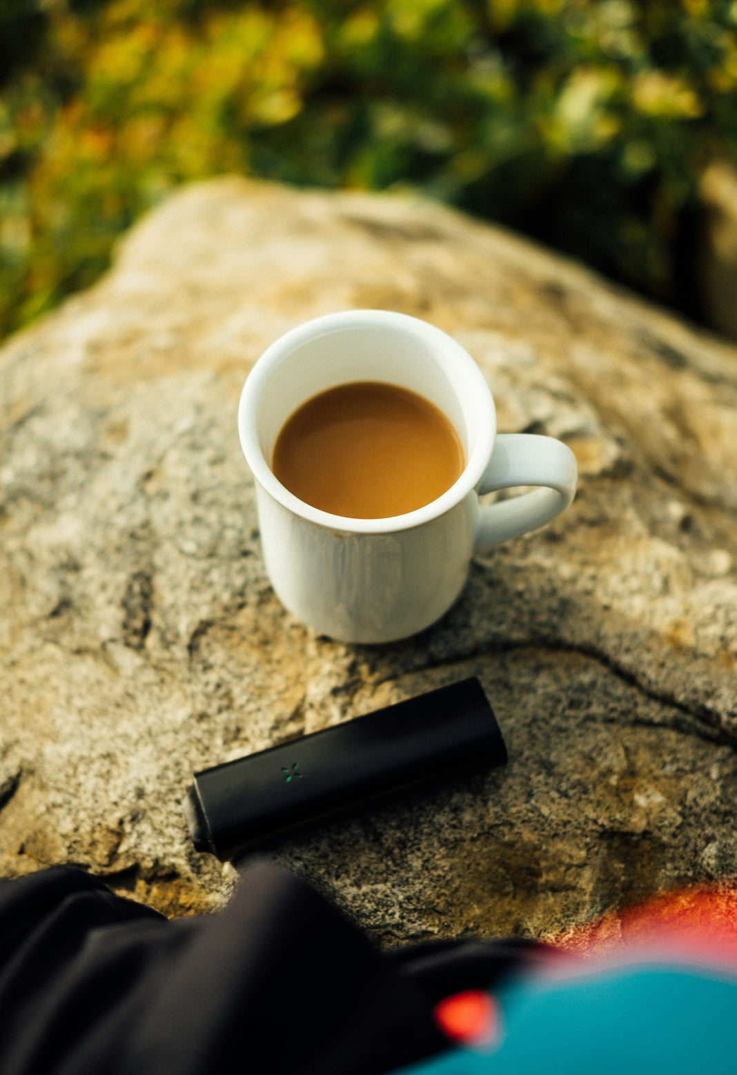 PAX vaporizer next to a cup of coffee